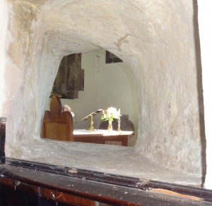 Hole in inner church wall allowing a view of the altar