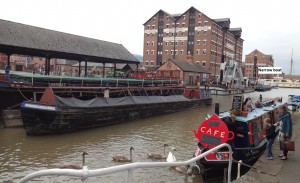 The tall building is the museum and a sign in while points to a narrow boat moored beside it
