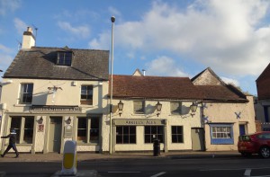 Pub beside the sale site including the building on the right with the blue trim, small window glass including a piece of bulls eye glass.